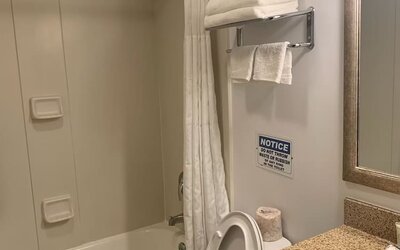 Guest bathroom with shower and tub at Sky Hotel Flushing - Laguardia Airport.