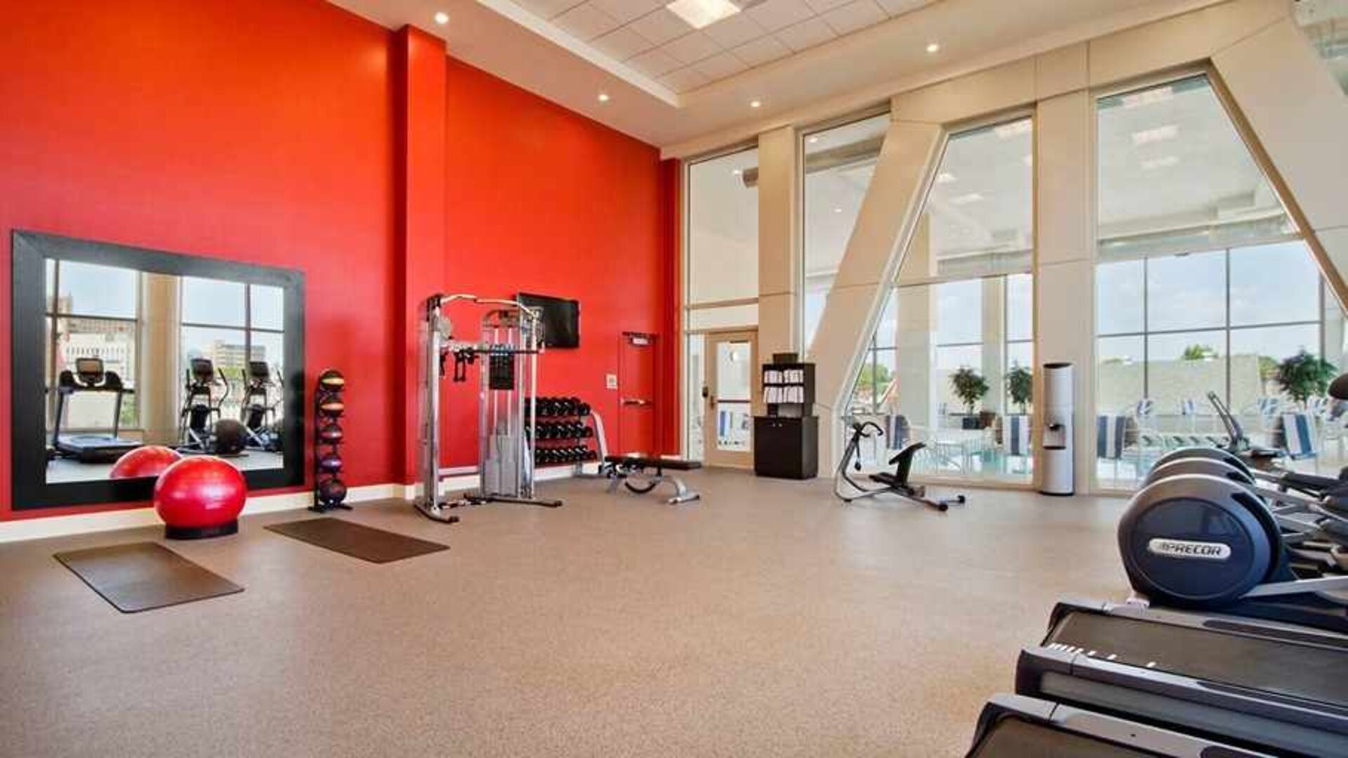 Well equipped fitness center with natural light at Homewood Suites by Hilton University City.