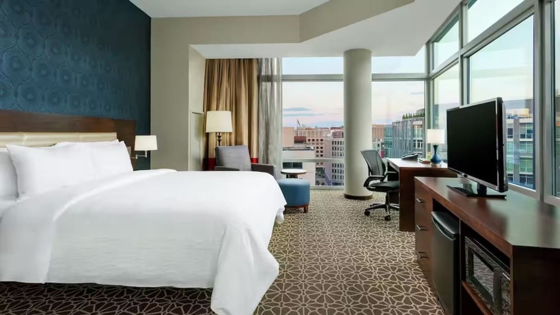 King bed with TV and natural light at Hilton Garden Inn Washington DC / Georgetown Area.