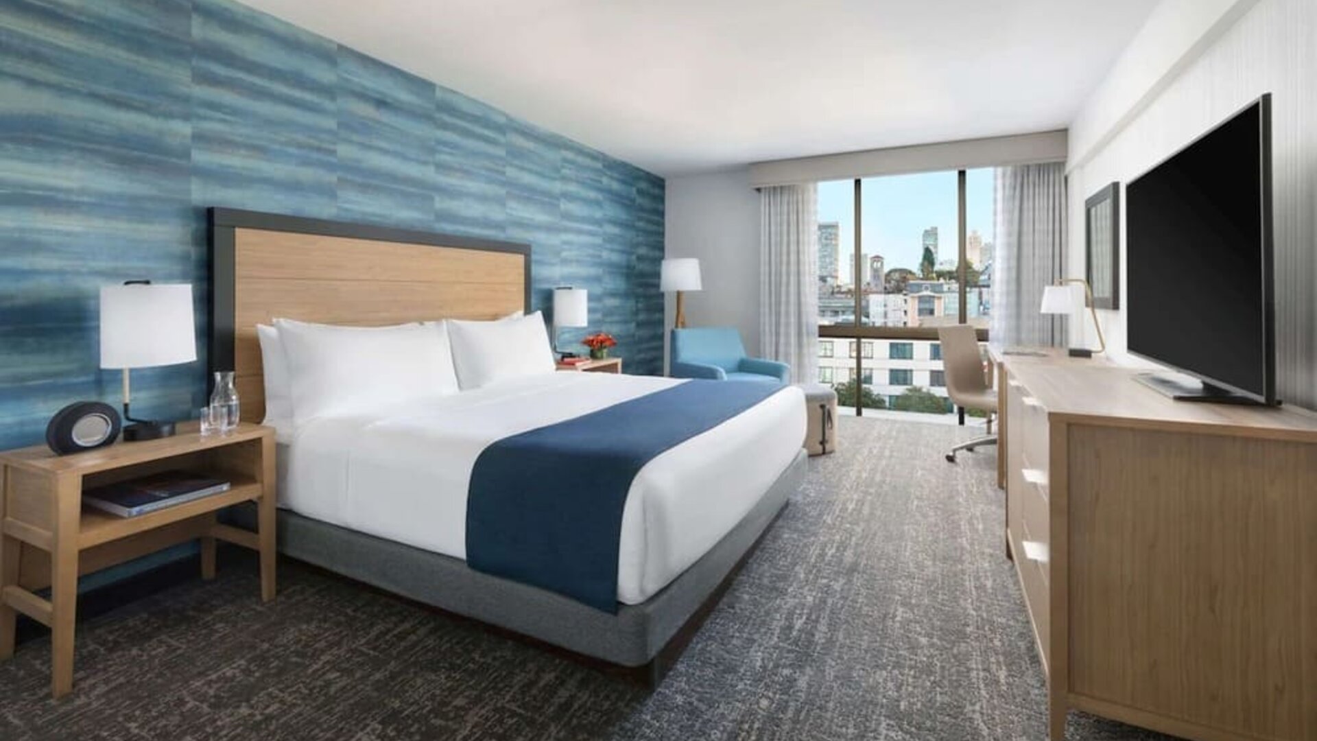 King bedroom with lots of natural light and work desk at Hotel Caza.