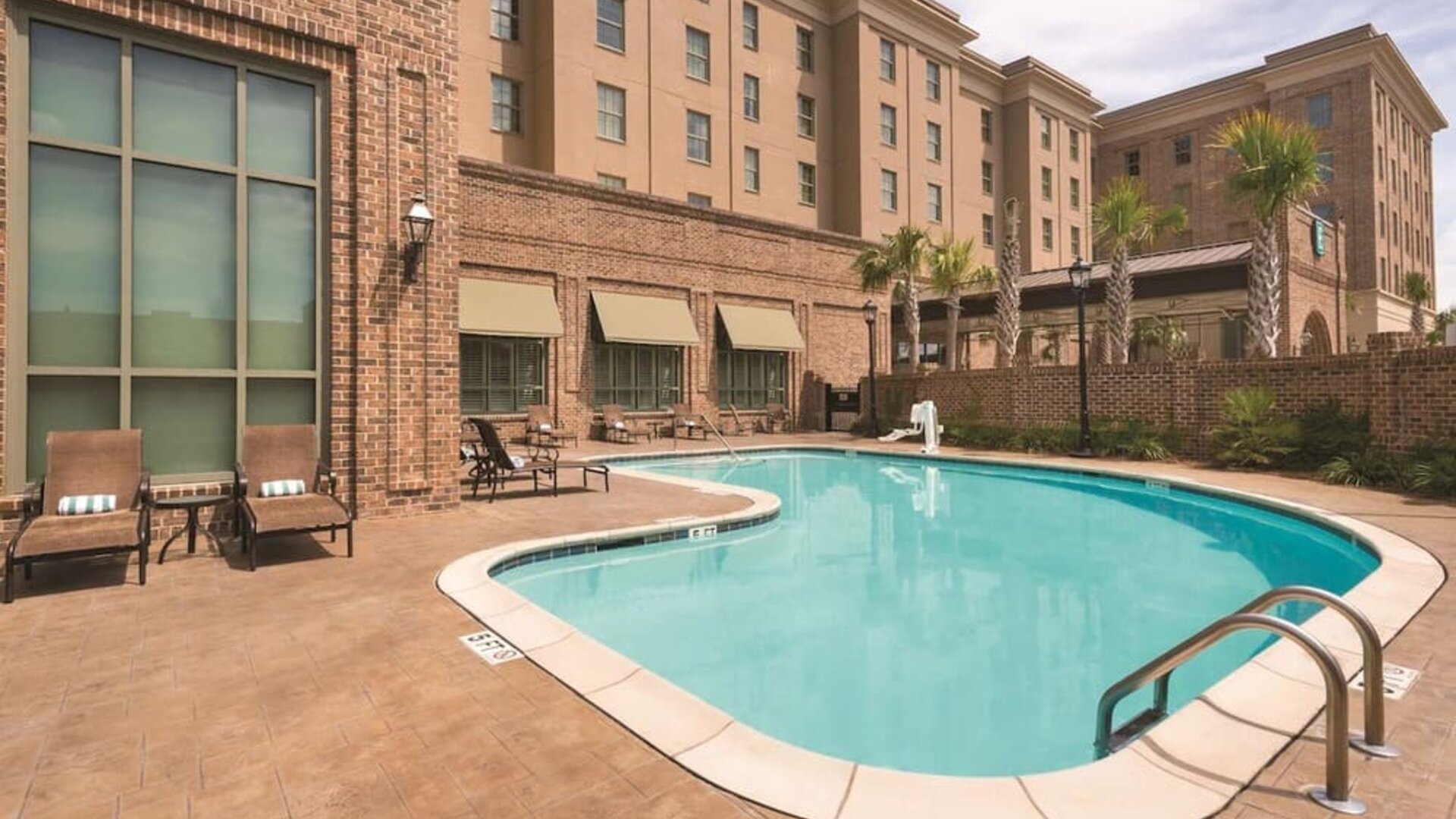 Outdoor pool with pool chairs at Embassy Suites By Hilton Savannah.