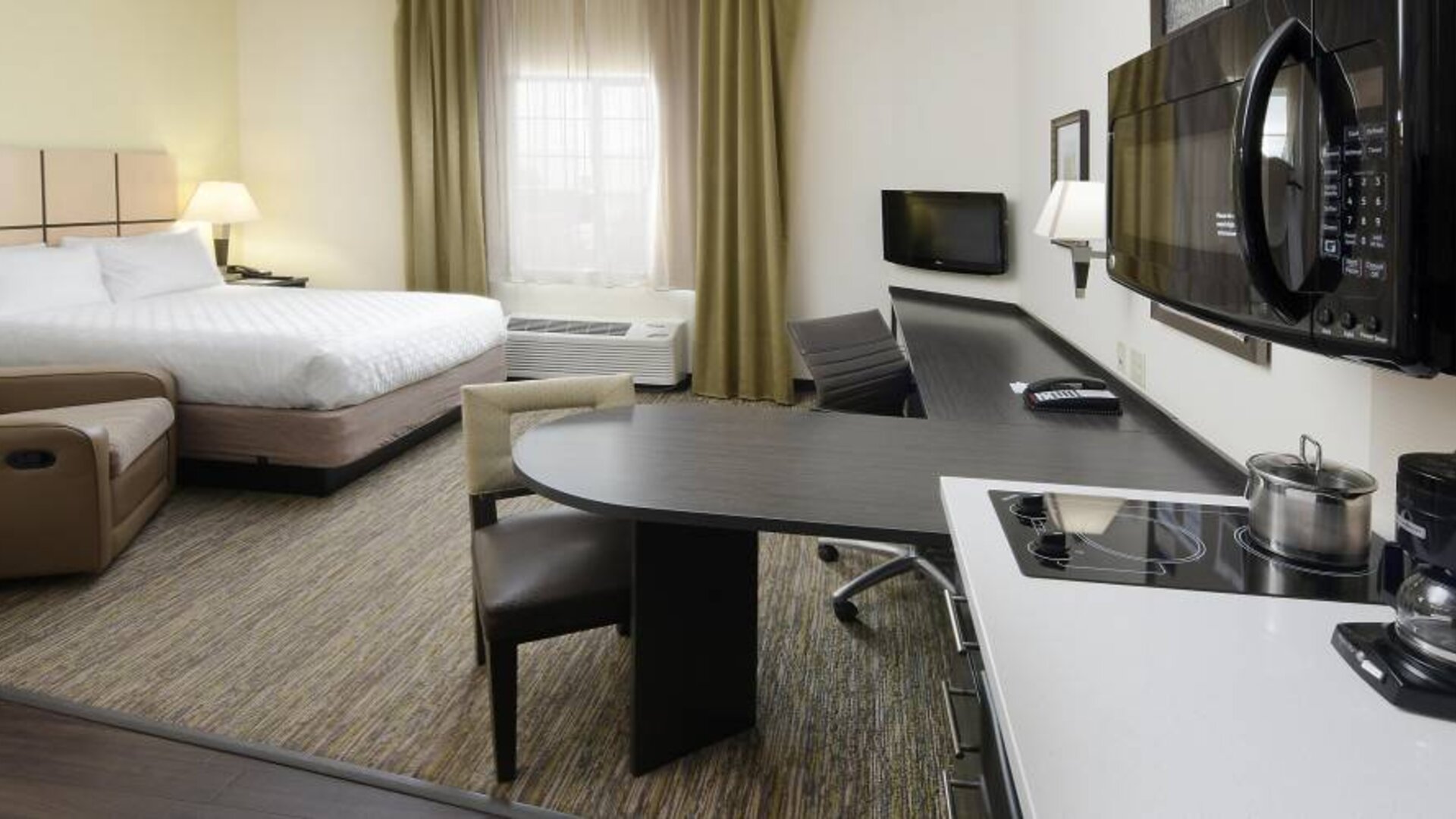 Day use room with work desk and kitchen at Candlewood Suites Odessa.