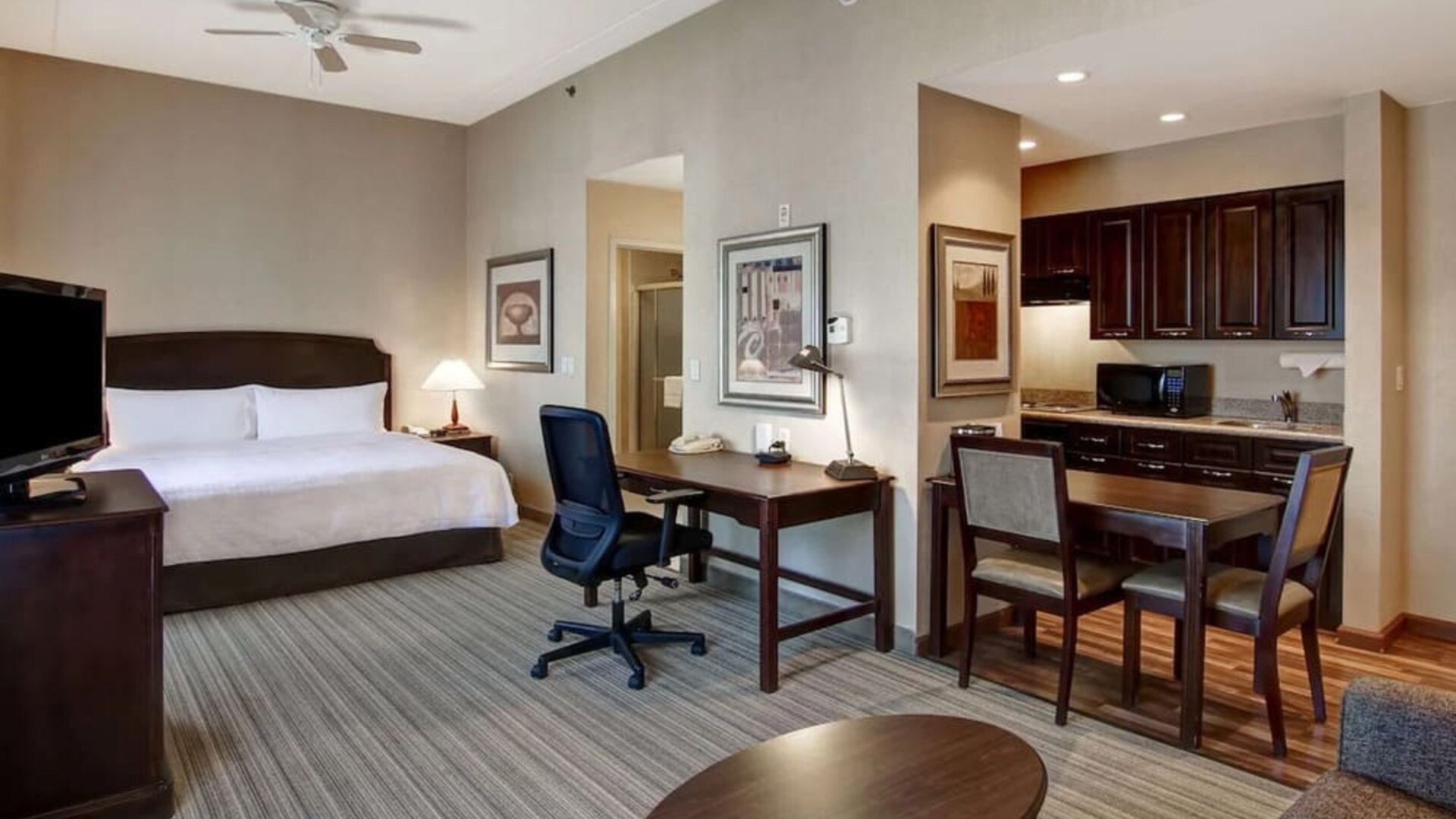 Spacious king bed with business desk at Homewood Suites By Hilton Burlington.