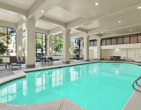 Lovely indoor pool with seating area at Embassy Suites By Hilton Arcadia Pasadena Area.
