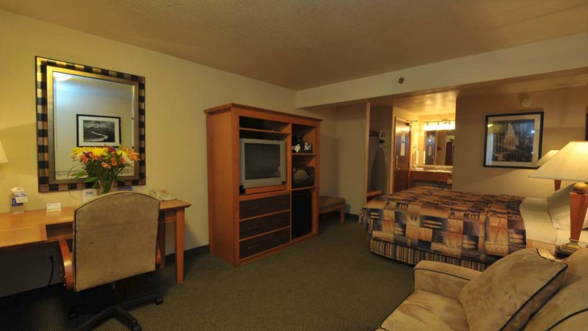 Day use room with work desk and sofa at Shilo Inn Rose Garden.
