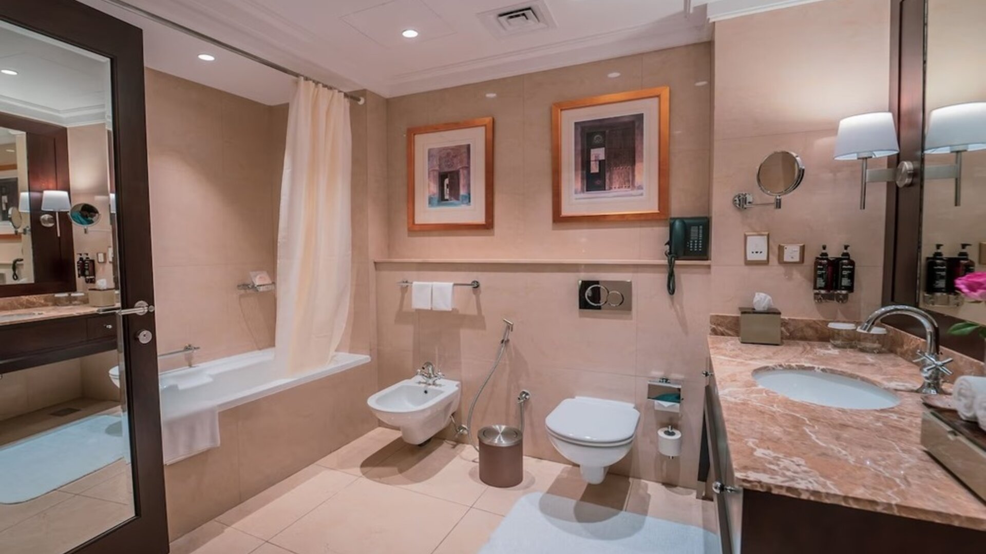 Guest bathroom with shower and bath at Millennium Hotel Doha.