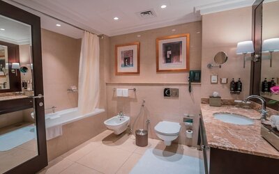 Guest bathroom with shower and bath at Millennium Hotel Doha.