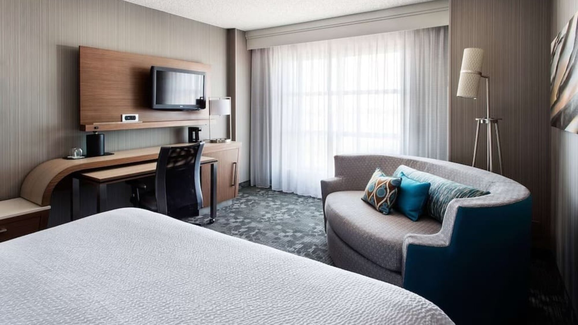 Delux king bed with TV at Sonesta Emeryville - San Francisco Bay Bridge.