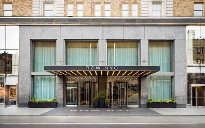Main entrance façade of Row NYC featuring sleek urban architecture and illuminated signage in Midtown Manhattan.