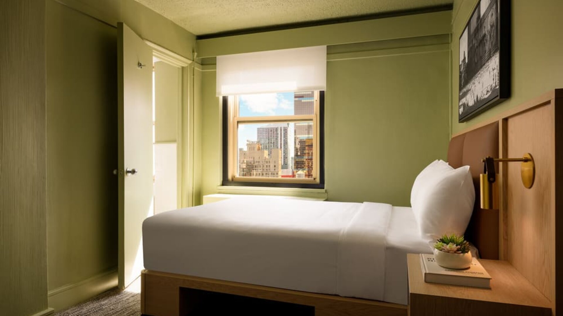Cozy guest room with natural light, city views, and minimalist modern furnishings at Row NYC.