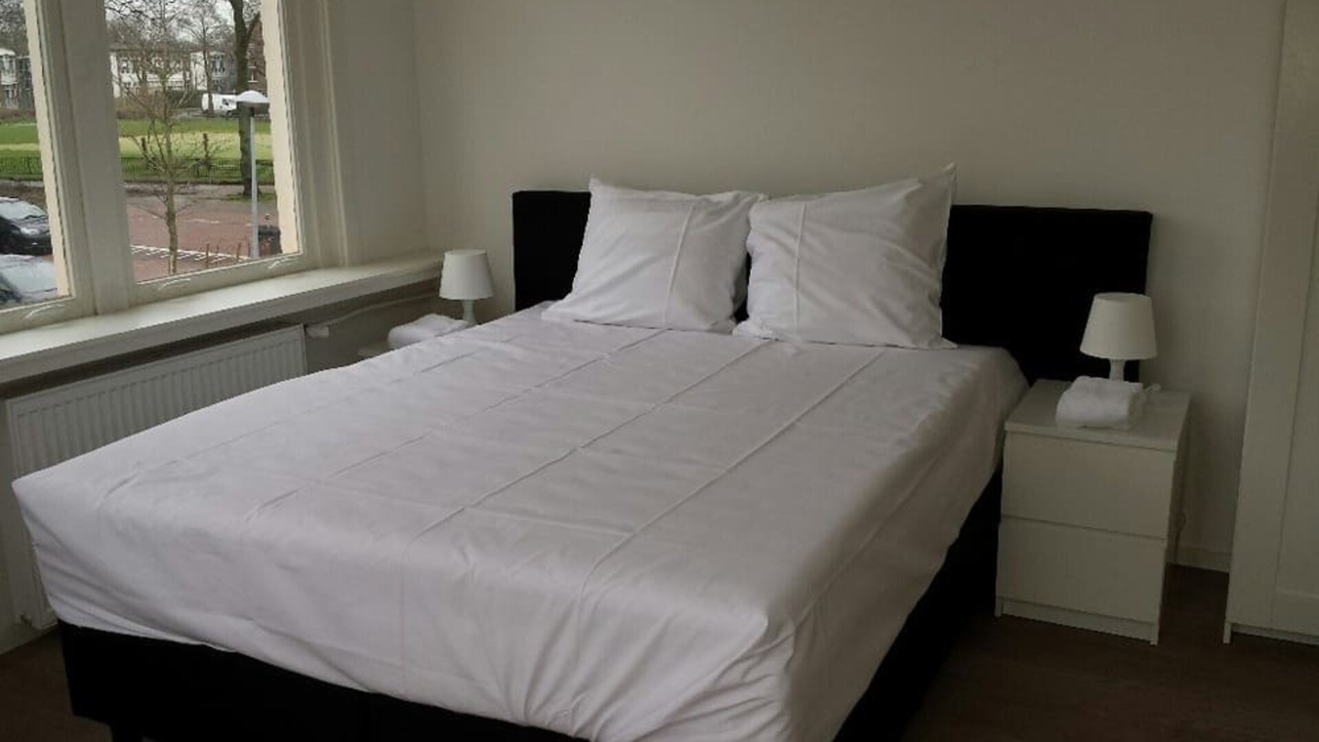 Bright king bedroom featuring large windows, comfortable bedding, and minimalist décor at Hotel Chao 24/7.