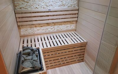 Private in-room sauna with wooden seating, stone heater, and relaxing wellness amenities at Hotel Chao 24/7.