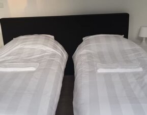 Twin guest room with two single beds, bedside tables, and crisp white linens at Hotel Chao 24/7.