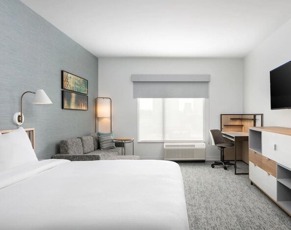 Bright-lit day use room with work desk and sofa at TownePlace Suites Nashville Midtown.