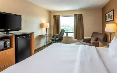 Double bed guest room in Comfort Inn Truro, with sofa and TV.