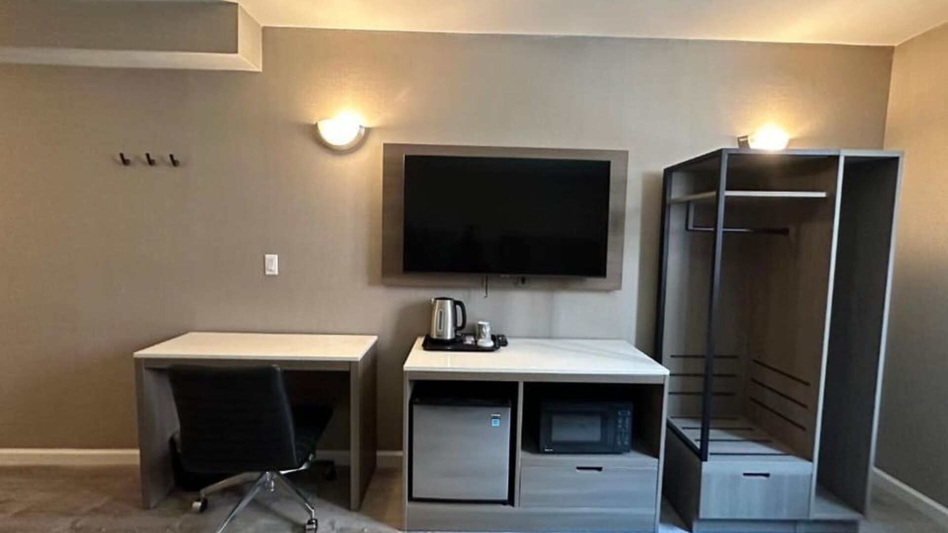 Dayroom with TV, mini-fridge, and work space at Regal Inn & Suites New York.