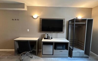 Dayroom with TV, mini-fridge, and work space at Regal Inn & Suites New York.