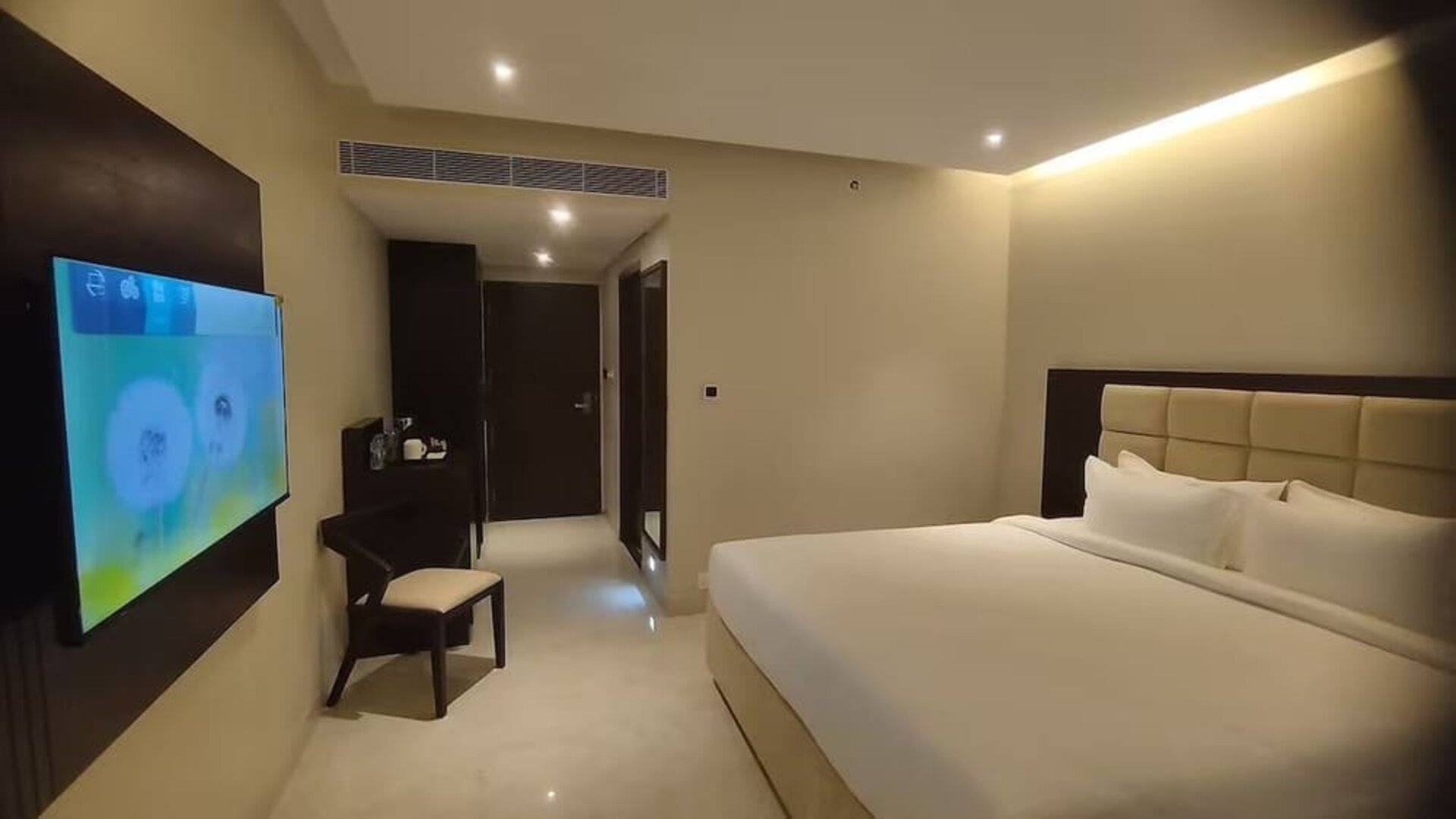 King bed with TV at Mayur Belgaum Presidency Hotel & Spa.