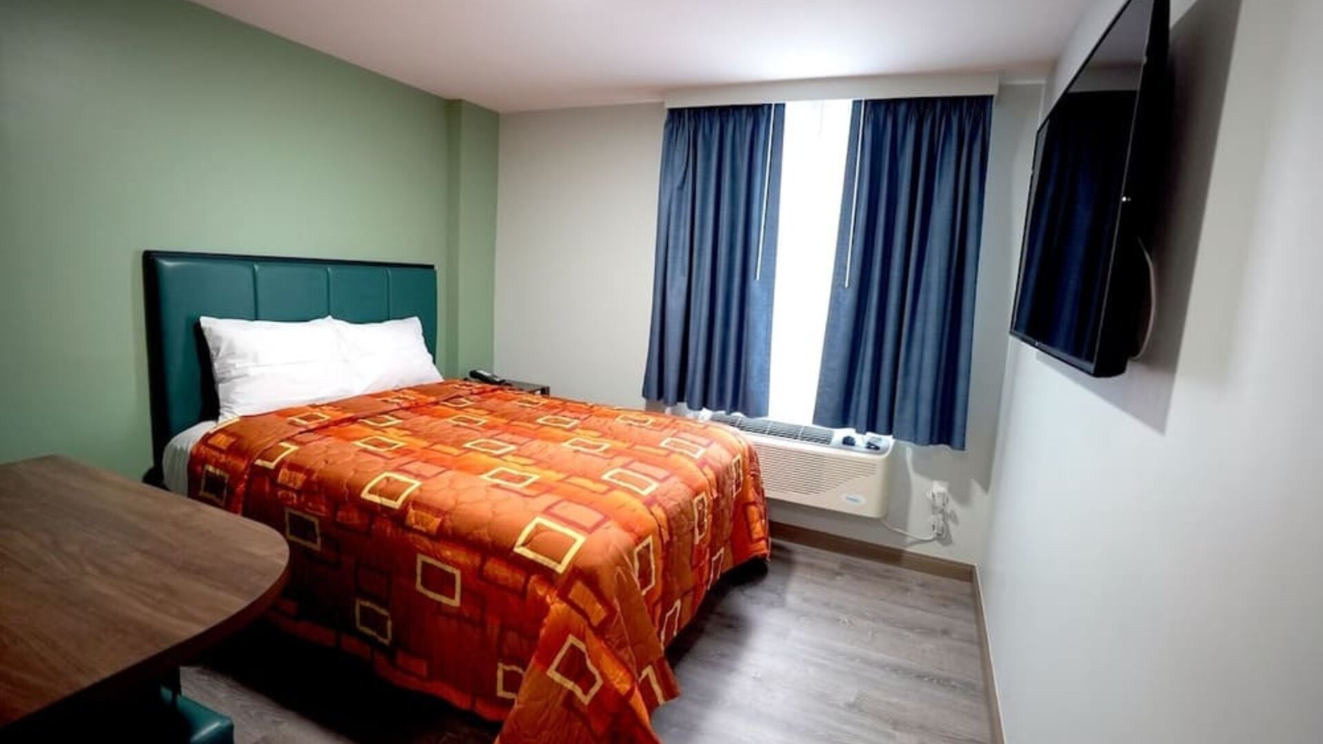 King bed with natural light at Hotel Liberty Inn & Suites.