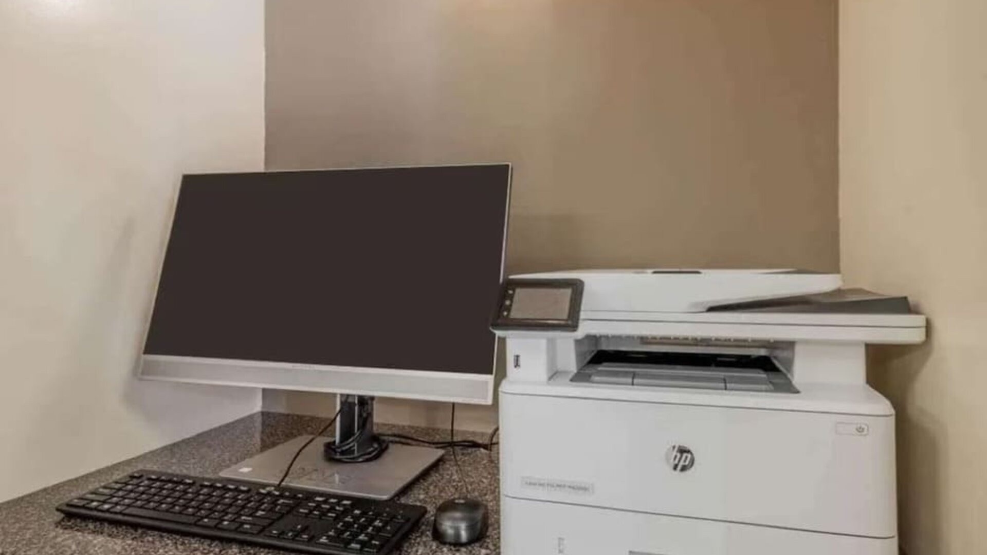 Hotel business center workstation, including monitor, keyboard, mouse, and printer.