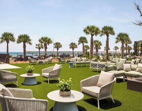 Terrace with sea view and lounge seating at Embassy Suites By Hilton Panama City Beach Resort.
