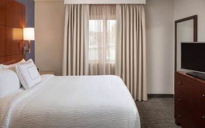 Sonesta ES Suites Nashville Brentwood guest room, featuring deluxe king bed, TV, and window.