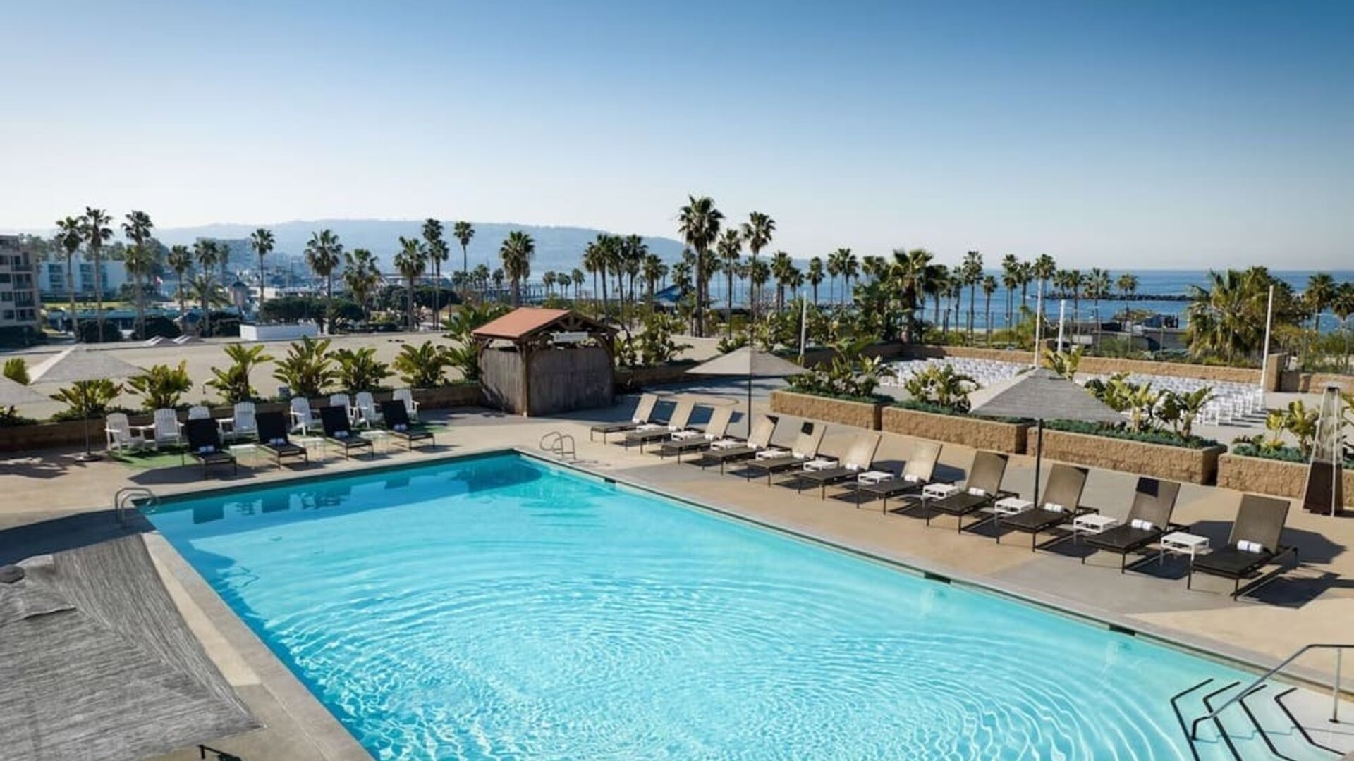 Stunning outdoor pool area with pool chairs at Sonesta Redondo Beach & Marina.