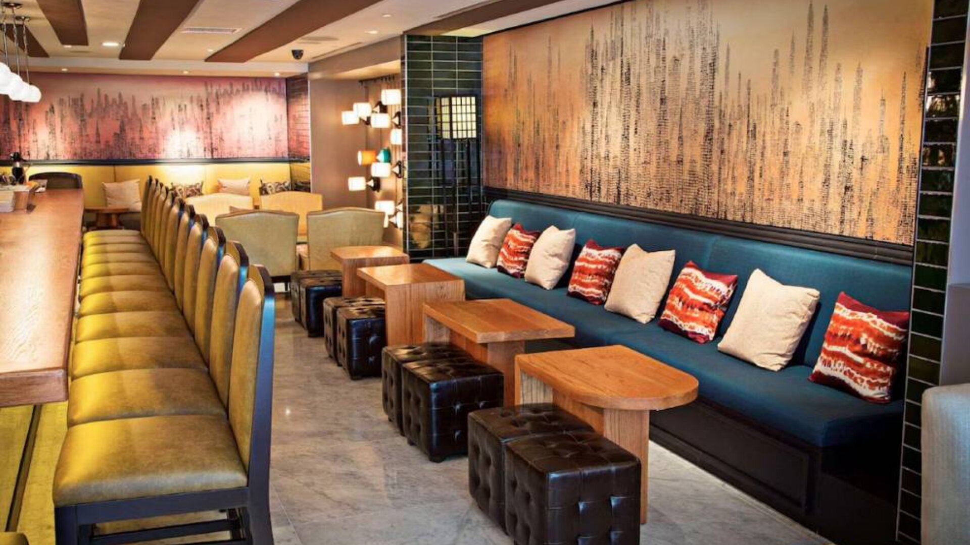 The hotel bar has a mix of traditional tall stools and table seating, and a hard floor.