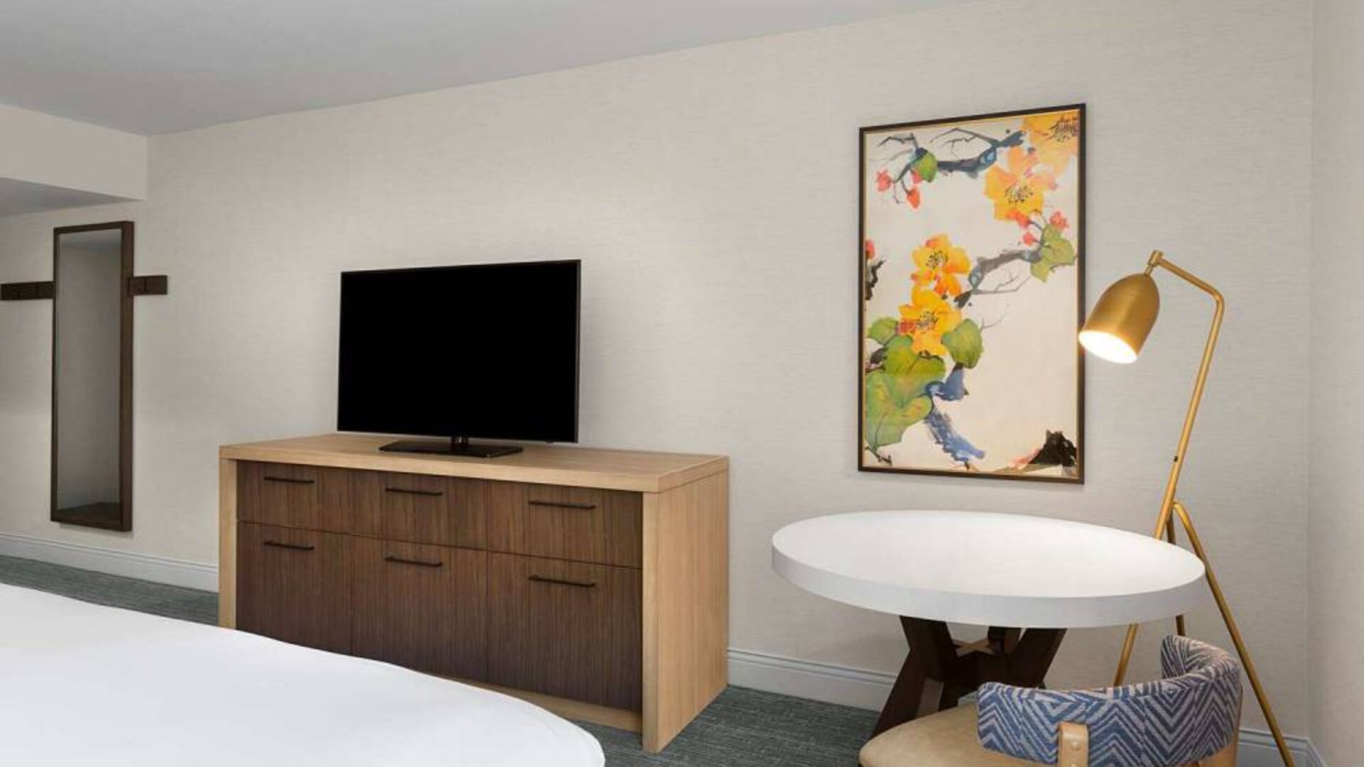 Double bed guest room in Sonesta Silicon Valley, furnished with widescreen television, and workspace desk, chair, and lamp.