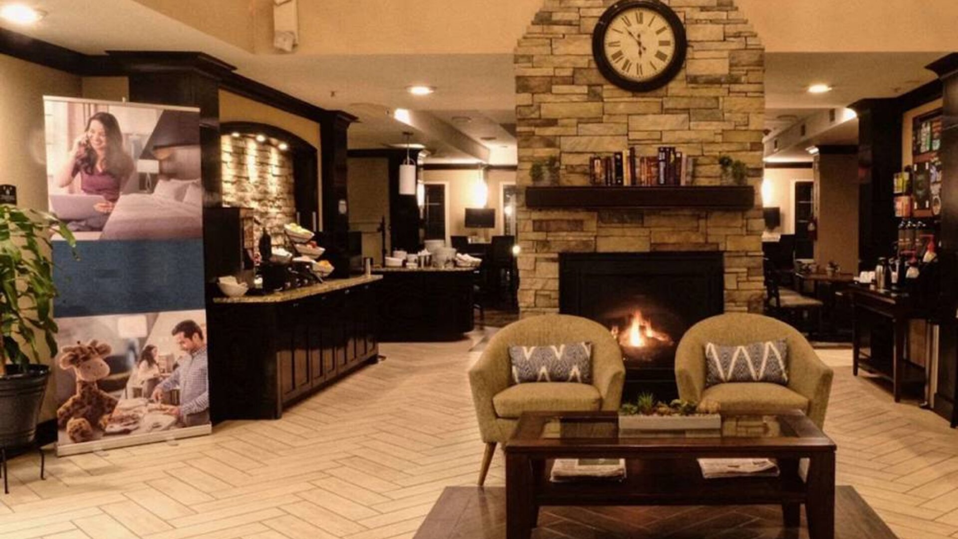 The hotel’s lobby has comfortable seating, a coffee table, reading material, and a cozy fireplace.