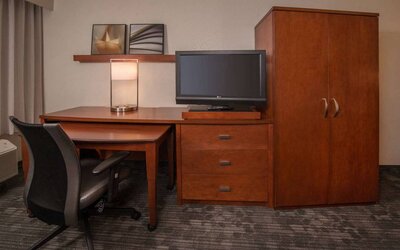Sonesta Select Arlington Rosslyn guest room workspace, including desk, chair, lamp, and TV.