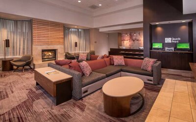 Sonesta Select Arlington Rosslyn’s lobby lounge has comfortable sofa and chair seating, coffee tables, and a fireplace.