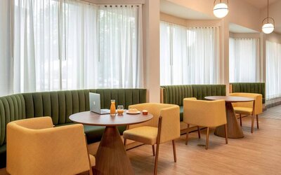 The hotel’s breakfast area has comfy seating, stylish tables, and large windows.