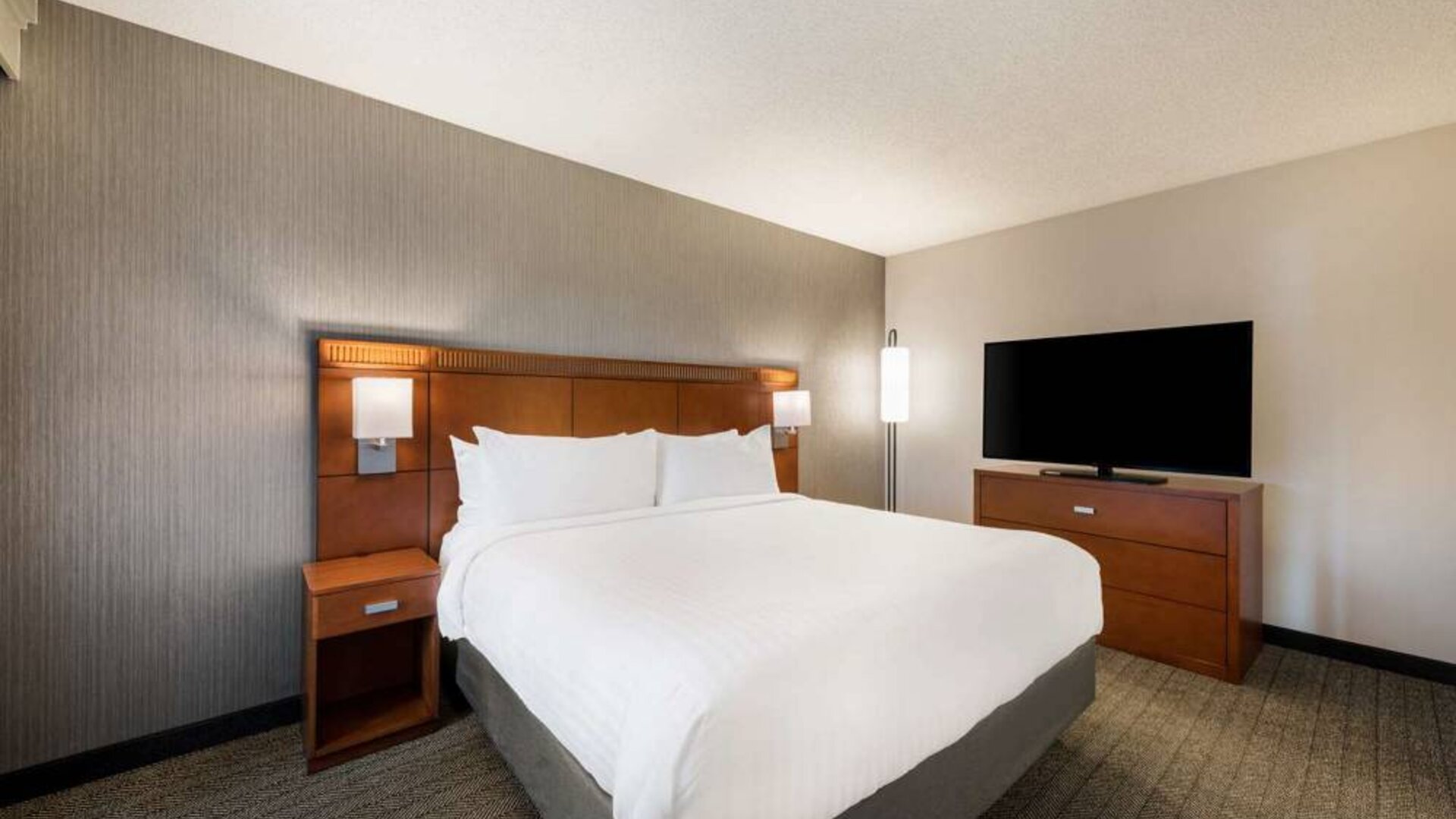 Sonesta Select San Jose Airport double bed guest room, including a large widescreen television.