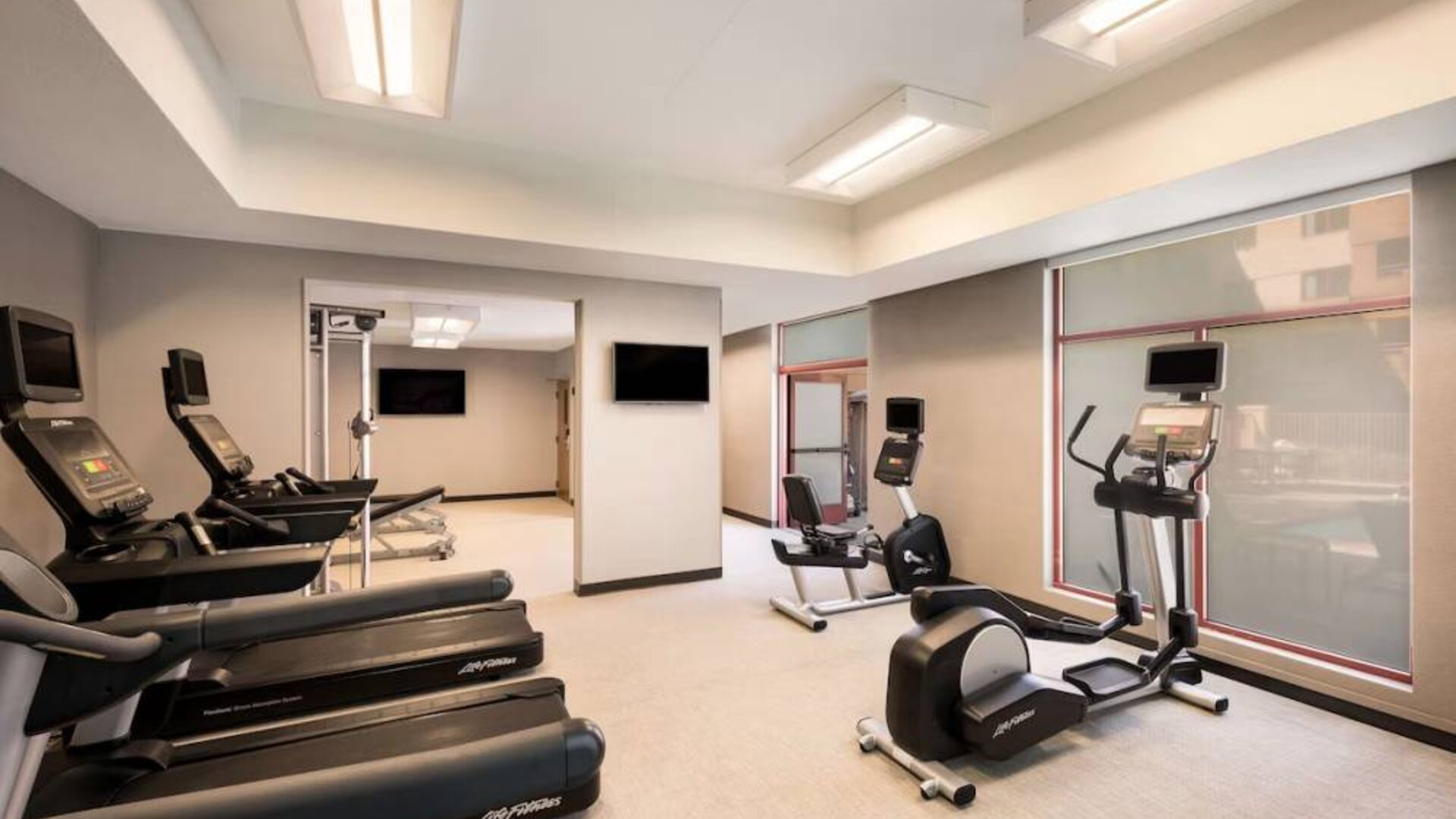 Sonesta Select San Jose Airport’s fitness center is equipped with a range of exercise machines and a wall-mounted TV.