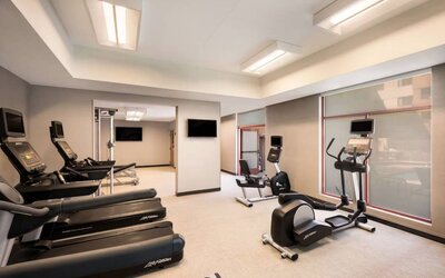Sonesta Select San Jose Airport’s fitness center is equipped with a range of exercise machines and a wall-mounted TV.