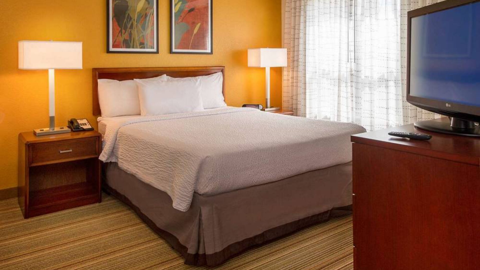 Double bed guest room in Sonesta ES Suites Charlottesville University, featuring window and widescreen TV.