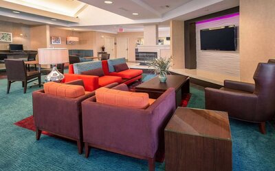 The hotel’s lobby lounge features comfortable chairs facing a widescreen, wall-mounted TV, with coffee tables close at hand.