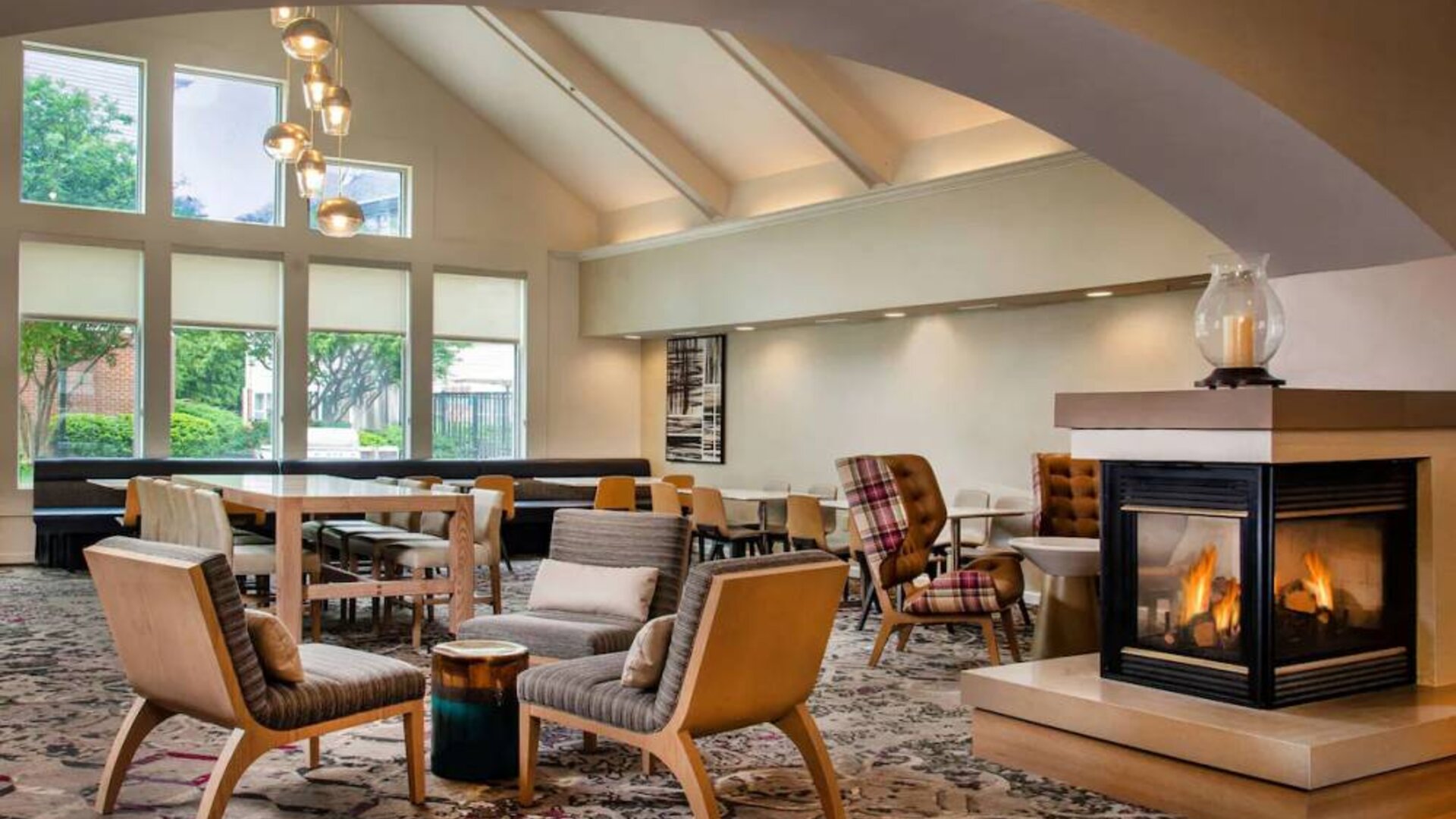 The hotel’s lobby lounge has large windows, extensive seating, coffee tables, and a fireplace.