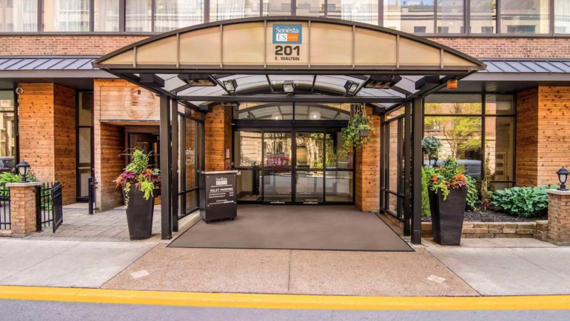 Sonesta ES Suites Chicago Downtown Magnificent Mile - Medical’s exterior has a covered entranceway and numerous potted plants.