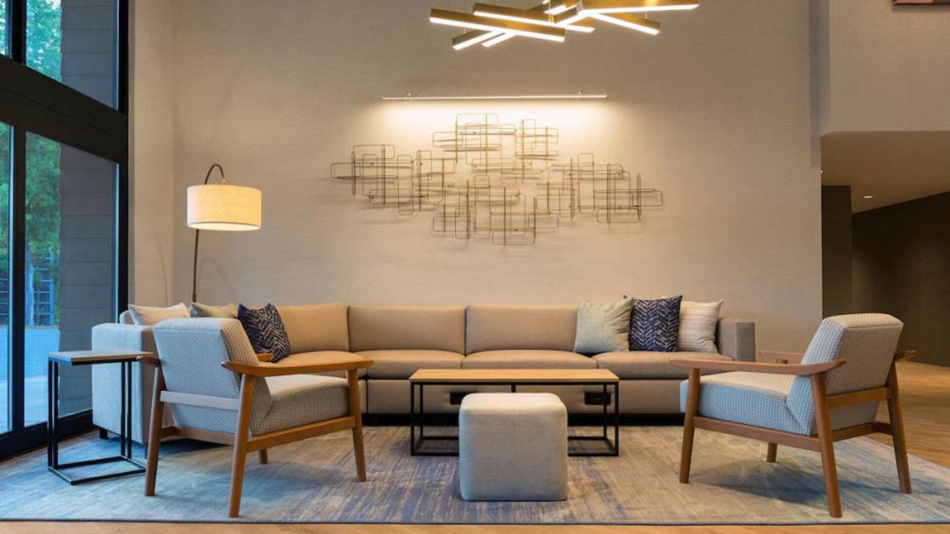 Sonesta Silicon Valley’s lobby is furnished with a comfortable sitting area, with long sofa, chairs, and multiple coffee tables.