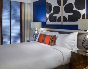 Royal Sonesta Washington DC Dupont Circle double bed guest room, featuring bedside lamps, art on the wall, and window.