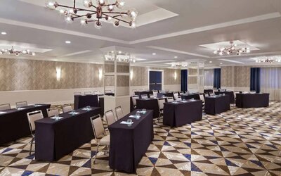 Large meeting room in Royal Sonesta Washington DC Dupont Circle, with tables of three seats each arranged in a classroom style.