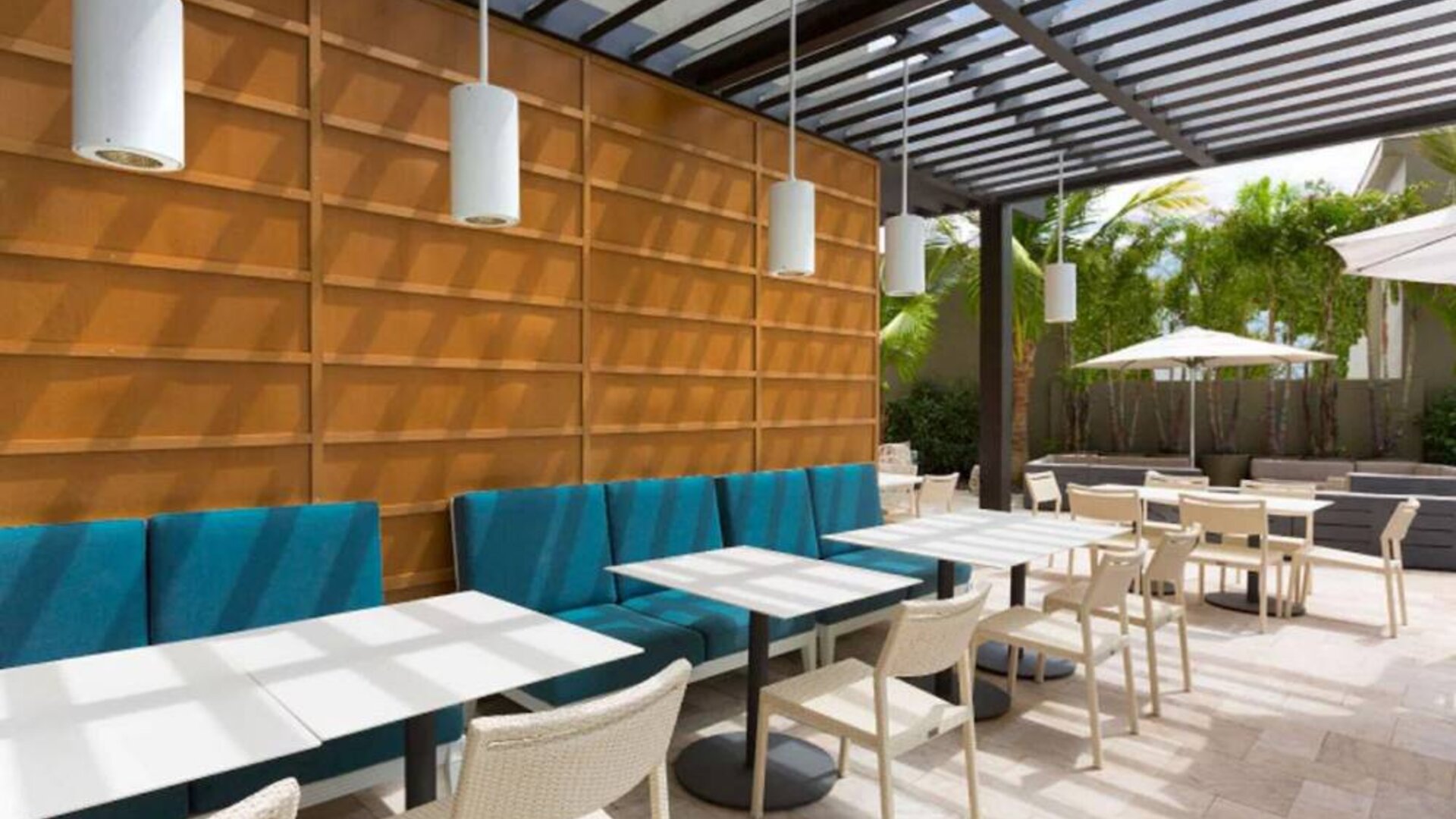 The hotel patio features tables and chairs where guests can relax and socialize in the open air.