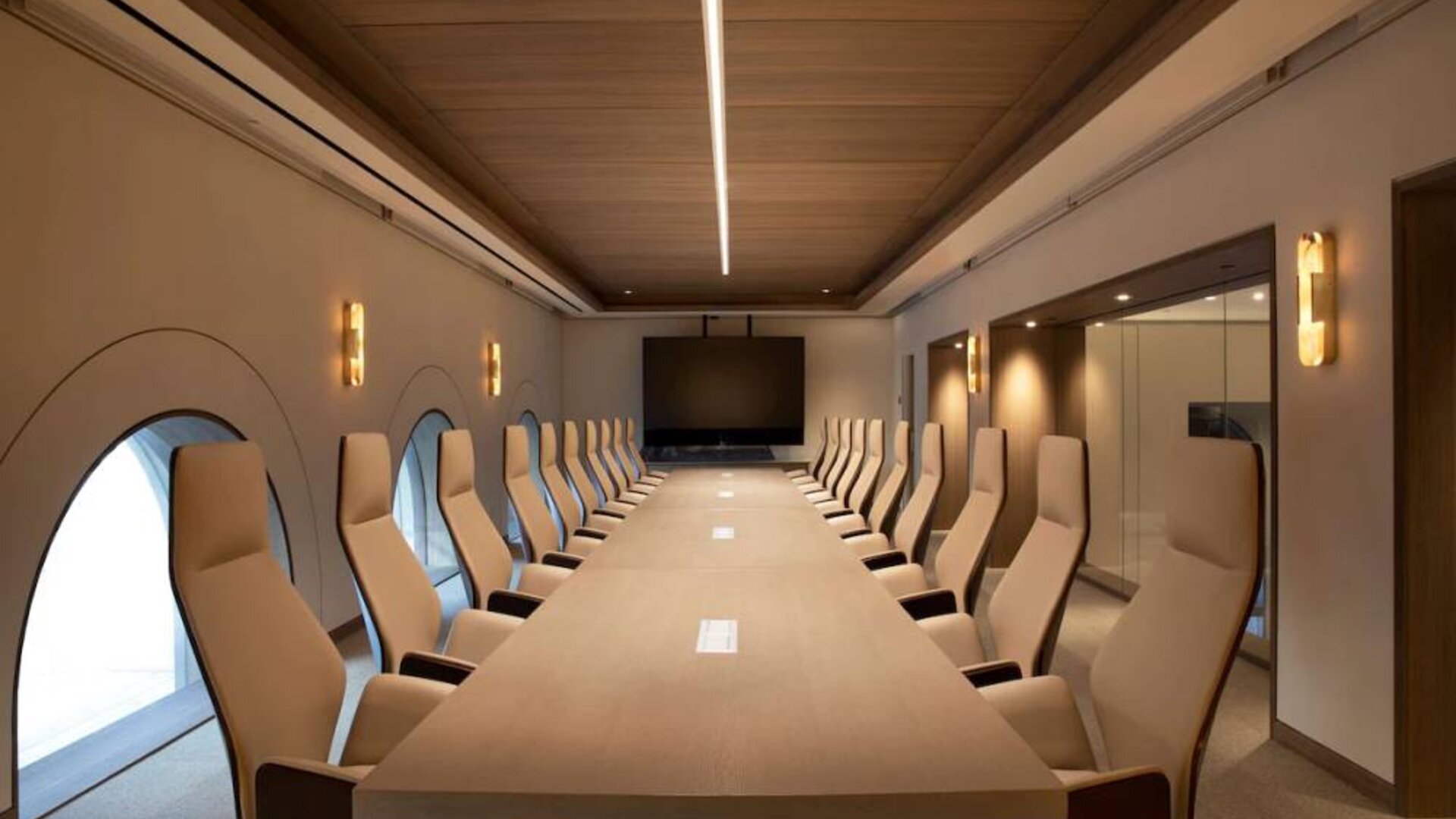 Meeting room in The Clift Royal Sonesta, featuring long table with seating for over a dozen attendees, cozy atmosphere, and large, wall-mounted TV.