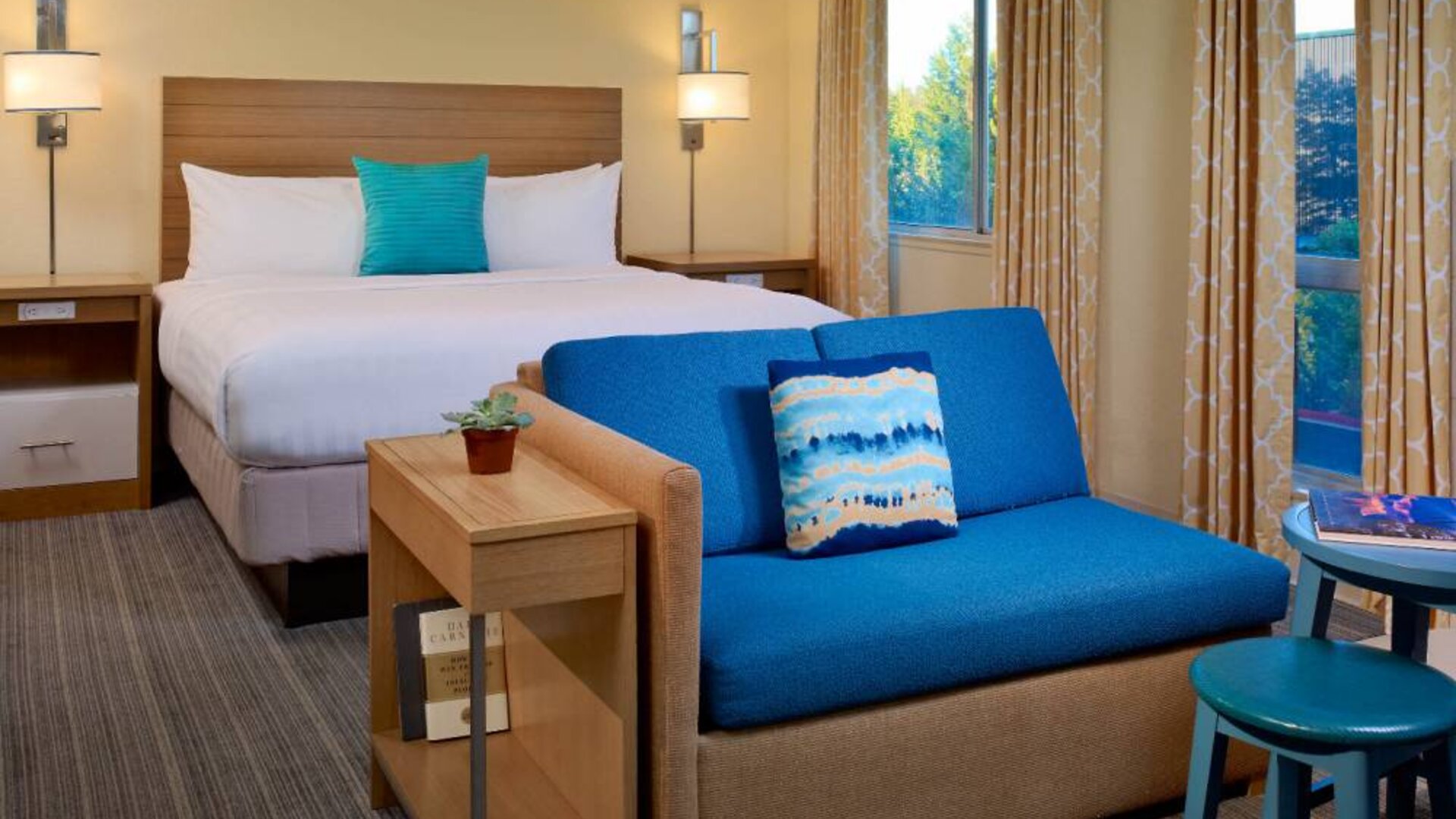 Double bed guest room in Sonesta ES Suites Flagstaff, including large windows and a sofa.