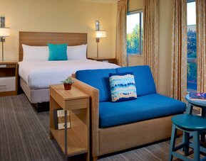 Double bed guest room in Sonesta ES Suites Flagstaff, including large windows and a sofa.