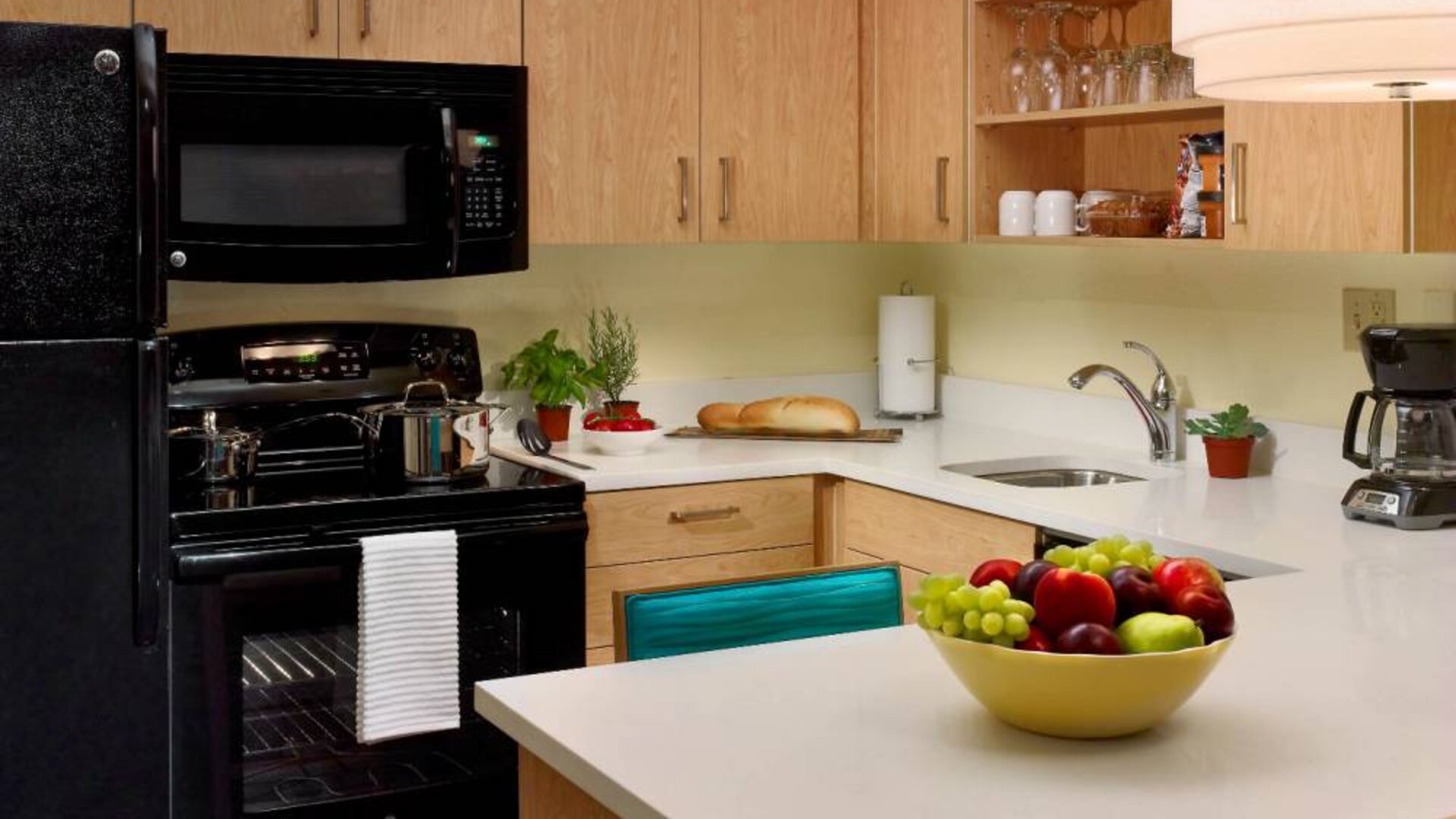 Sonesta ES Suites Flagstaff guest room kitchen, furnished with microwave, oven and hob, and fridge-freezer.