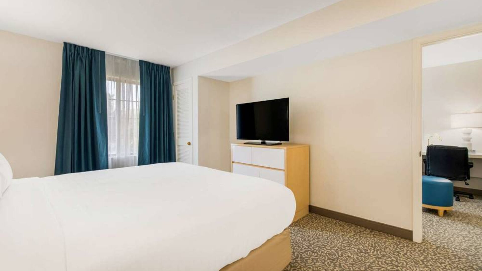 Double bed guest room in Sonesta ES Suites Charlotte Arrowood, including window and television.