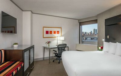 Royal Sonesta Boston double bed guest room, including workspace desk and chair, plus television.